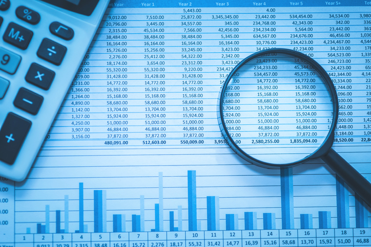 Financial records being examined with a magnifying glass