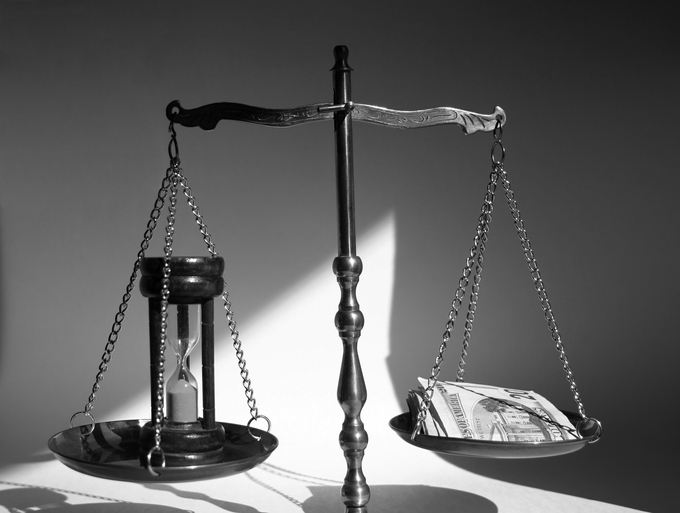 Balance scale comparing time and money in evaluating the economics of a business dispute