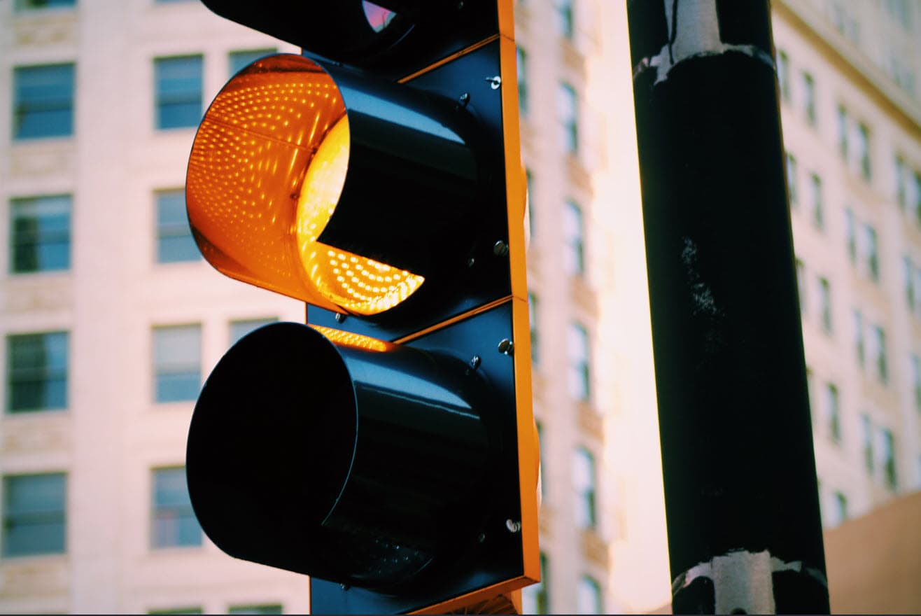 Yellow traffic light at intersection - caution should be exercised before proceeding